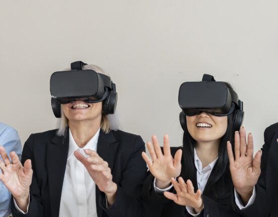 Group of multiracial colleagues meeting in office using VR headset - metaverse concept -